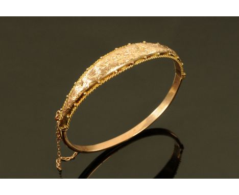 A 9 ct gold bangle, with safety chain, 7 grams.