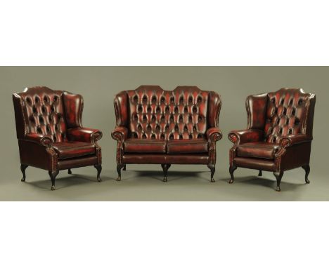A three piece oxblood leather lounge suite, comprising settee and two chairs, each raised on cabriole legs. CONDITION REPORT: