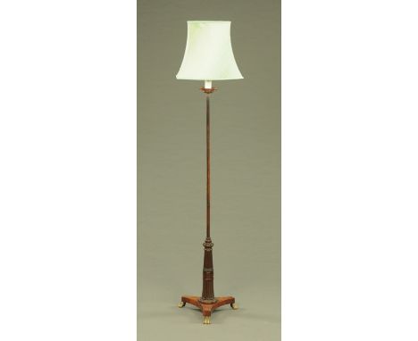 A Regency mahogany pole screen (converted to standard lamp), plain shaft leading to a fluted stem and with triform base with 