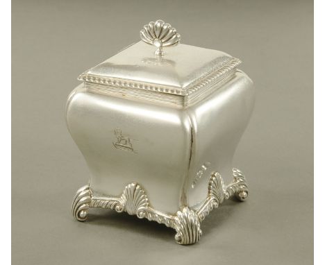 An Edward VII silver square tea caddy, with waisted body and scroll feet, with palmette finial to the lid, London mark 1908, 