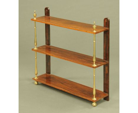 A Regency rosewood three tier open shelf unit, with brass finials and column supports and with front ball feet.  Width 74 cm,