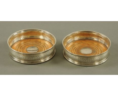 A pair of George III decanter coasters, engraved with armorial hallmarks, rubbed.  Diameter 13.5 cm (see illustration).