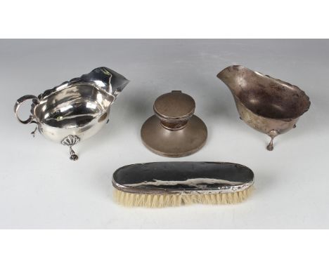 An Edwardian silver sauce boat with flying scroll handle and scallop shell shouldered scroll legs terminating in hoof feet, C