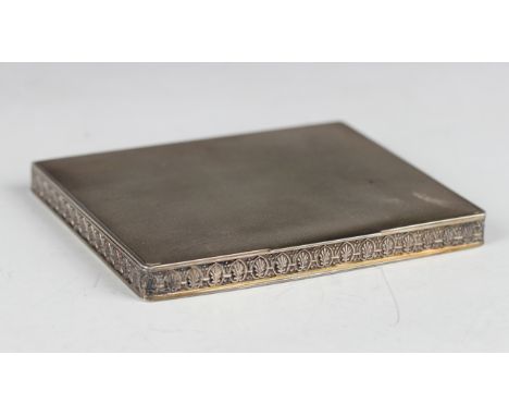 A George VI silver rectangular compact with engine turned decoration, the sides with a band of anthemion, the hinged lid inte