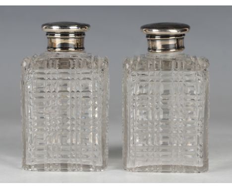 A pair of Victorian square cut glass perfume bottles and stoppers with silver screw caps, London 1853 by Thomas Johnson, heig