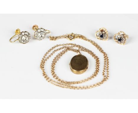 A gold oval pendant locket with engine turned decoration, unmarked, weight 1.6g, length 2.5cm, with a gold oval link neckchai