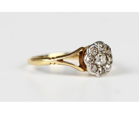 A gold and diamond nine stone cluster ring, mounted with cushion cut diamonds between split shoulders, unmarked, weight 1.4g,