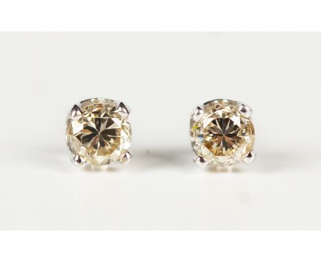 A pair of white gold and diamond single stone earstuds, each claw set with a circular cut diamond, the posts detailed '14K', 