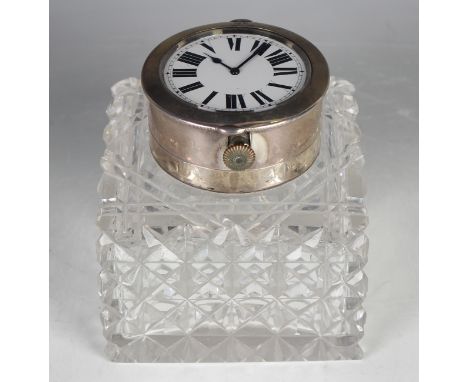 An Edwardian silver and cut glass square inkwell, the silver collar with hinged lid, fitted with a double-sided keyless wind 