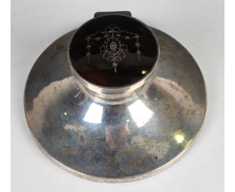 A George V silver and tortoiseshell capstan inkwell with glass liner, the hinged lid piqué inlaid with pendant and floral gar