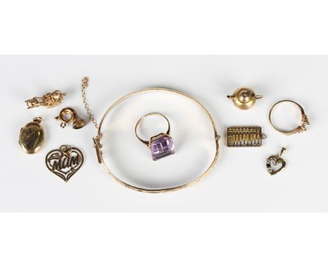 A gold ring, claw set with a cut cornered rectangular step cut amethyst, detailed '9c', a 9ct gold oval pendant locket, two 9