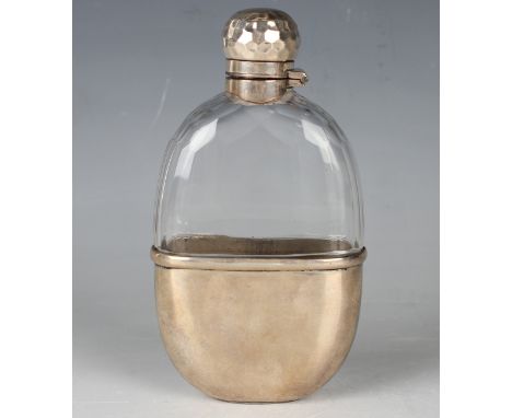 A late Victorian silver mounted faceted cut glass hip flask, the screw hinged lid with hammered decoration, fitted with a pla