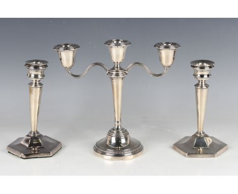 An Elizabeth II silver candlestick with matching detachable twin scroll branch forming a three-light candelabrum with cast ri