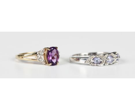 A 9ct gold ring, claw set with an oval cut amethyst between colourless gem set shoulders, Birmingham 2006, ring size approx N