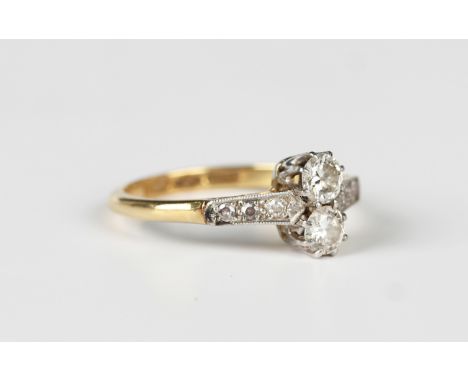 A gold, platinum and diamond ring, claw set with two principal circular cut diamonds between diamond three stone shoulders, d