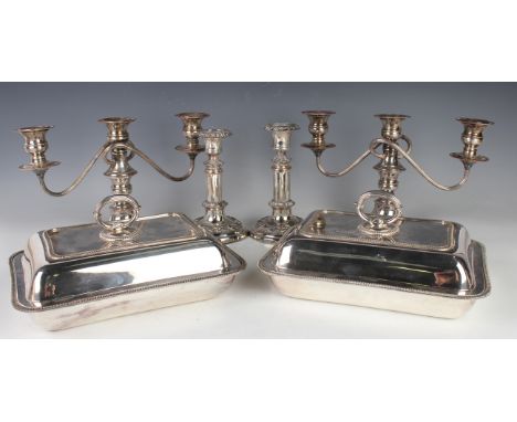 A group of plated items, including a pair of rectangular entrées dishes, covers and handles, a near pair of telescopic candle