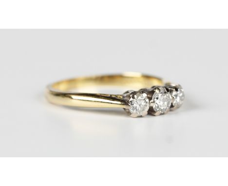 An 18ct gold and diamond three stone ring, claw set with a row of circular cut diamonds, Sheffield 1999, weight 3.3g, ring si