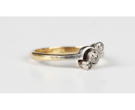 A gold, platinum and diamond three stone ring, collet set with a row of circular cut diamonds in a twistover design, detailed