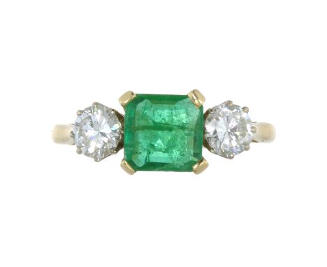 AN EMERALD AND DIAMOND THREE STONE RING in 18ct yellow gold, set with a central step cut emerald of 1.15 carats, between two 