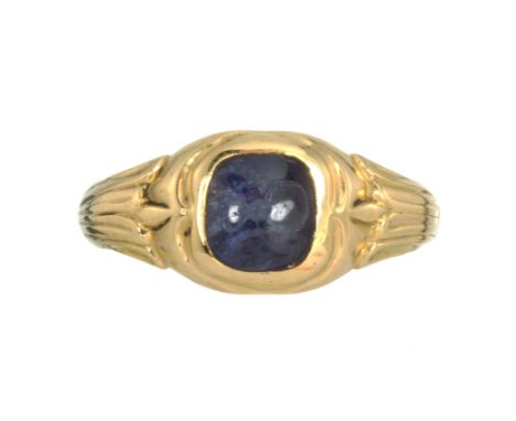 AN ANTIQUE SAPPHIRE RING, EARLY 19TH CENTURY in 18ct yellow gold, set with a central oval cabochon blue sapphire between flut