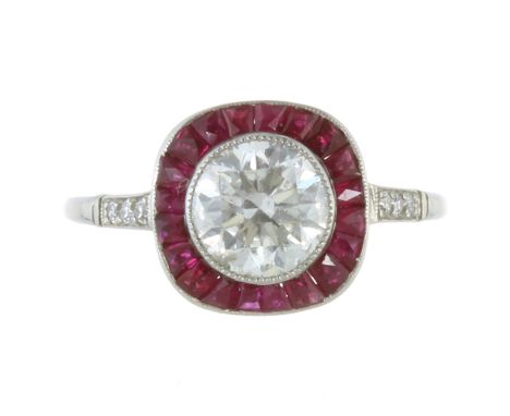 A DIAMOND AND RUBY DRESS RING in white gold or platinum set with a round cut diamond of 1.52 carats surrounded by a border of