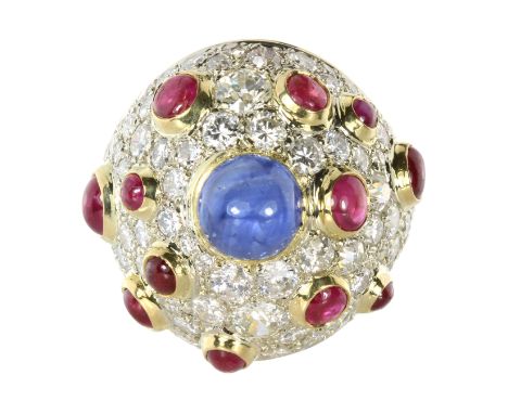 A SAPPHIRE, RUBY AND DIAMOND COCKTAIL RING in high carat yellow gold, of bombe form set with a central round cabochon blue sa