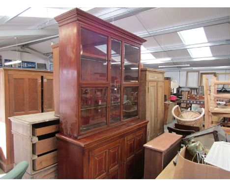 A large 19th Century mahogany shop display cabinet with bevelled glass doors, revealing shelved and brass rails with hooks to