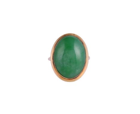 A NATURAL JADEITE JADE DRESS RINGThe polished oval cabochon jadeite jade within a gold coloured surround, with polished gold 