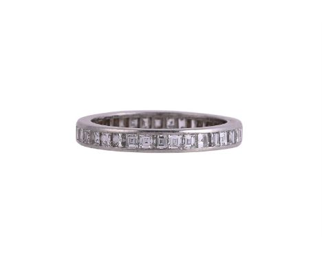 CARTIER, A DIAMOND ETERNITY RING CIRCA 1975The ring channel set with step cut diamonds, approximately 2.04 carats total, sign