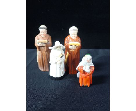THREE ROYAL WORCESTER BONE CHINA CANDLESNUFFERS comprising two Benedictine monks and a nun, 12cm and 10cm high respectively, 