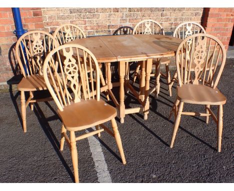 A SET OF SIX BEECHWOOD WINDSOR WHEELBACK CHAIRS (modern), and a similar gate-leg table with pine top, the table 92 x 133cm (o