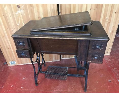 A cast iron pedal base sewing machine. Styled with wooden built cabinet with 4 drawers. White Rotary American sewing machine.