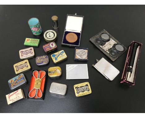 A Collection of odds which includes Vintage gramophone needle tins, Boxing medal, Optician items and Cloisonne shot glass. 