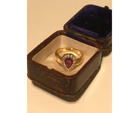 A Beautiful example of a 14ct gold ladies dress ring. Set with Diamonds surrounding a large tear drop ruby stone. 