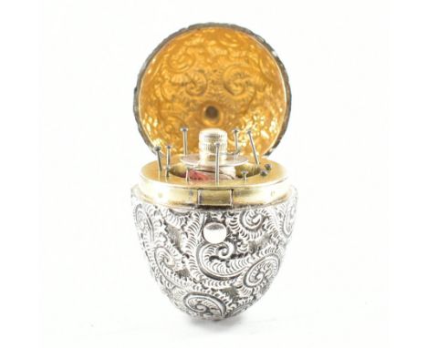 An antique silver &amp; gilt egg form sewing case. The sewing kit in the form of an inverted egg decorated throughout with re