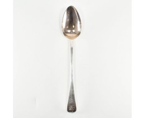 A Georgian hallmarked silver serving spoon. The spoon having a pointed round bowl with flared handle &amp; etched detailing d