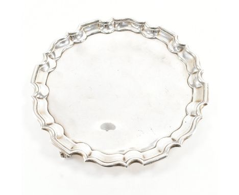 A hallmarked silver escargot footed salver. The tray of circular form having a stepped serpentine lip &amp; raised on three c