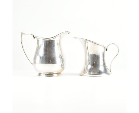 Two hallmarked silver jugs. The first jug of rounded form on a stepped plinth with angular thumb rest handle, hallmarked for 