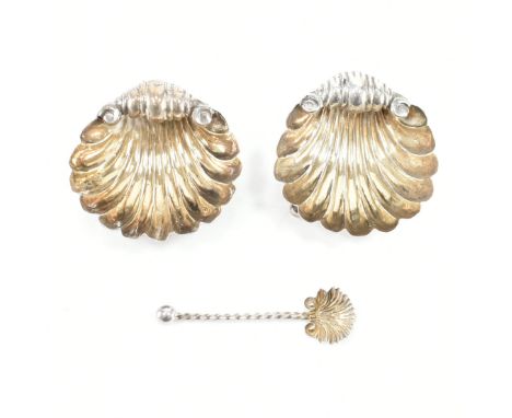 A pair of hallmarked silver &amp; gilt table salts. The condiments in the form of scrolling repousse scallop shells raised on