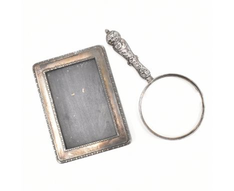 A silver fronted picture frame together with a silver handled looking glass. The picture frame having a beaded pattern to the