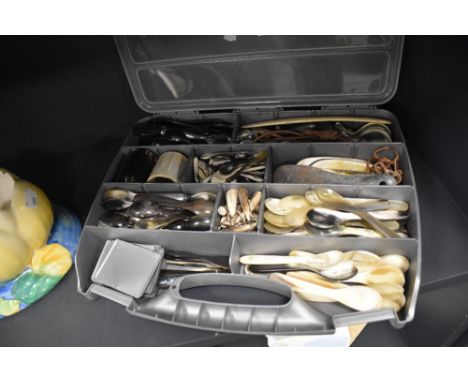 A large collection of carved animal horn items including spoons, stirrup cups and shoe horns etc