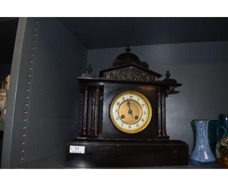 An antique chiming mantle clock of black polished stone having painted metal columns to sides, battle scene depicted to centr