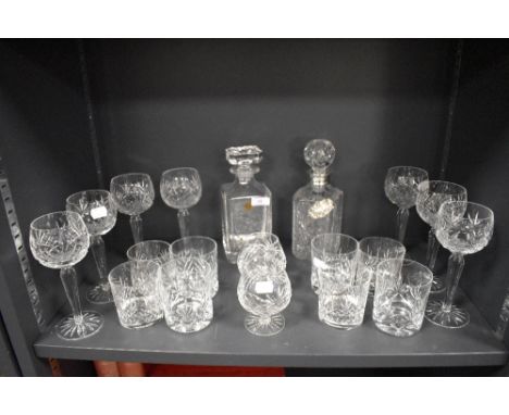 A mixed lot of cut glass and similar including decanters, one having silver brandy label, wine glasses, tumblers and more.