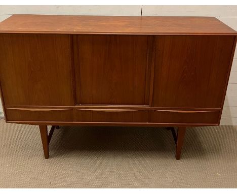 A Mid Century sideboard, three doors opening to shelves and drawers and three drawers to base on tapering legs (H141cm W167cm