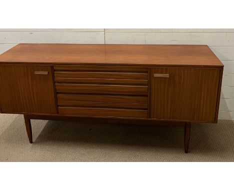 A Mid Century teak side board with drawers to centre and flanked by cupboards (H77cm W168cm D46cm)