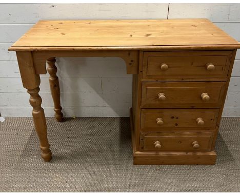 A pine dressing table with drawers to right and turned legs (H76cm W107cm D48cm)