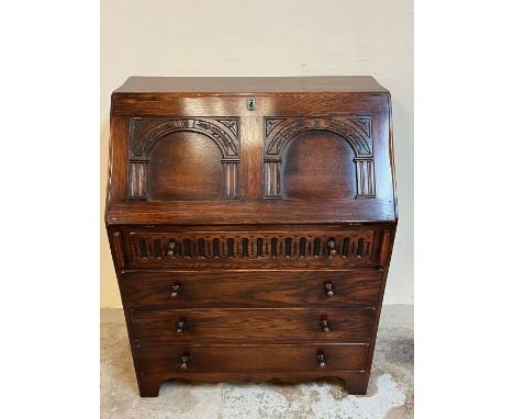 An oak bureau with fall front opening drawers pigeon holes (H97cm W77cm D45cm)
