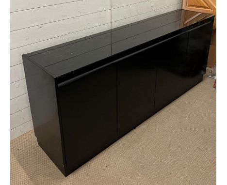 A black lacquer sideboard, four doors opening to adjustable shelfs and drawers (H76cm W180cm D40cm)