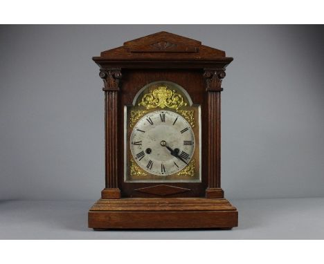 An oak cased mantel clock, brass and brushed steel face with brass spandrels, Roman dial, approx 27 x 39 x 14 cms.&nbsp;