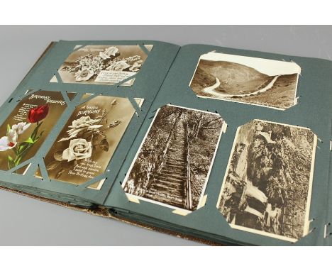A vintage postcard album, comprising Christmas postcards, black and white postcards of people and places, approx 200 cards.